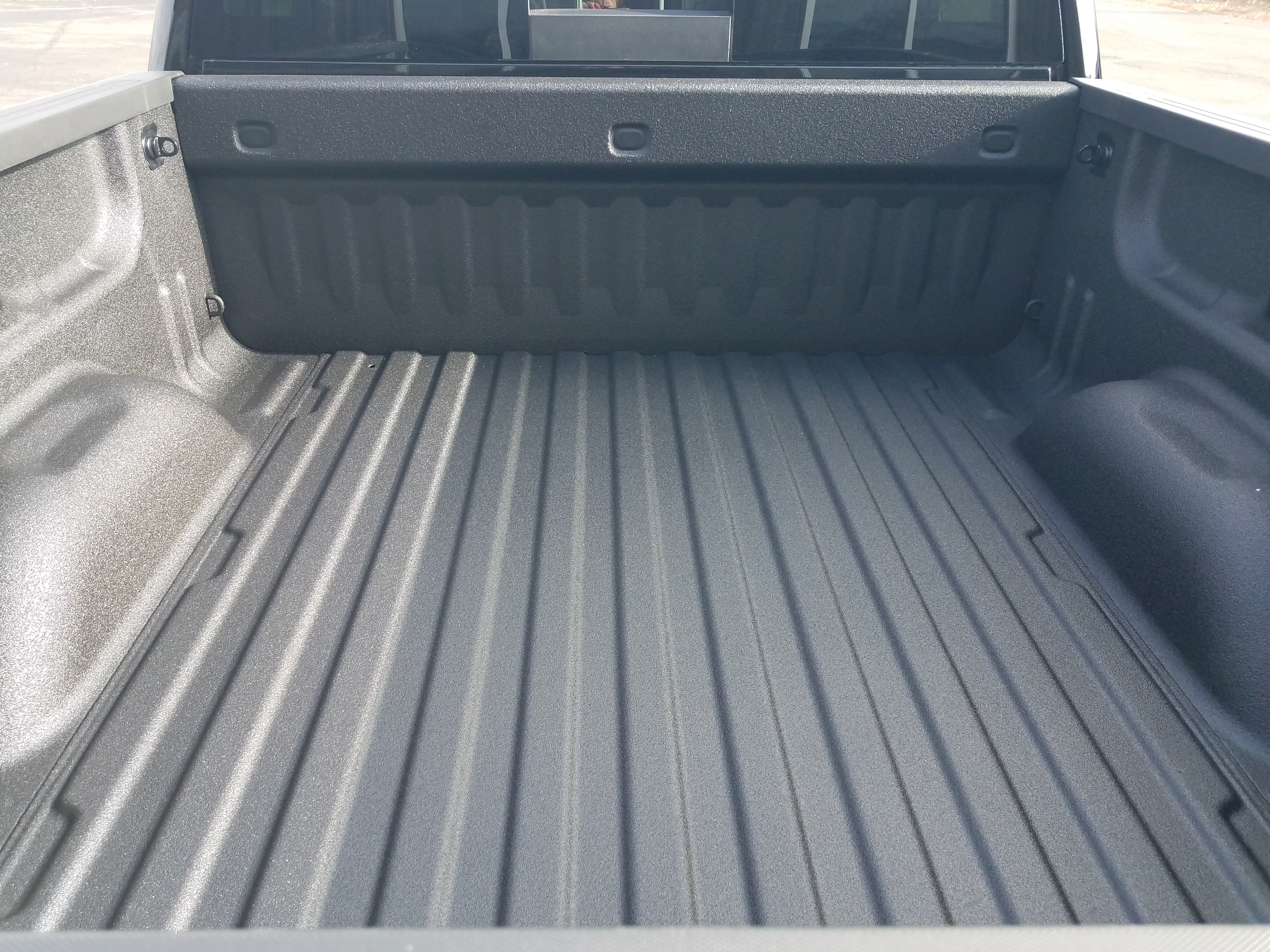 Close view of spray gun atomizing polyurea onto a truck bed