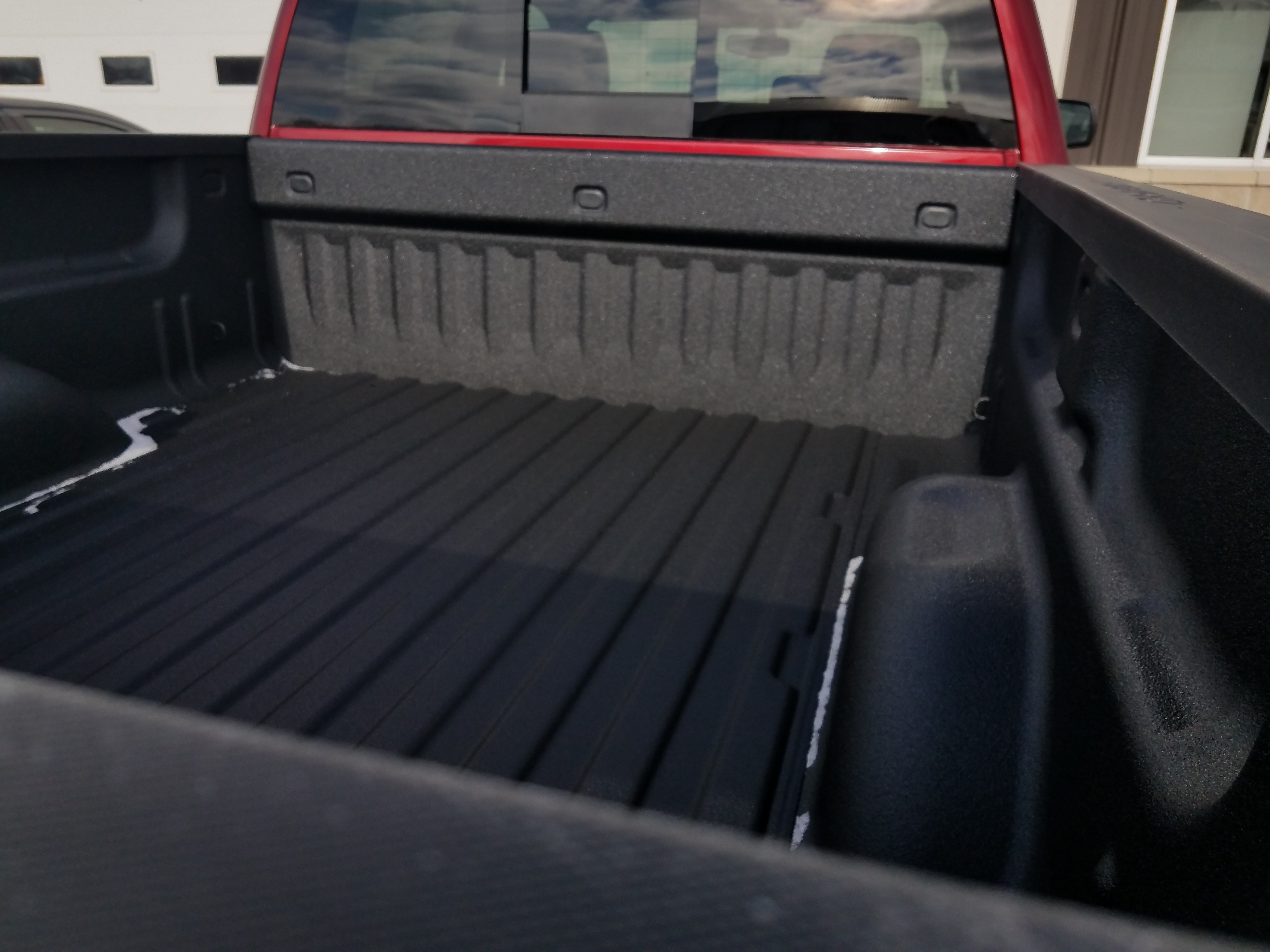 Spraying polyurea into the corners and seams of a pickup bed
